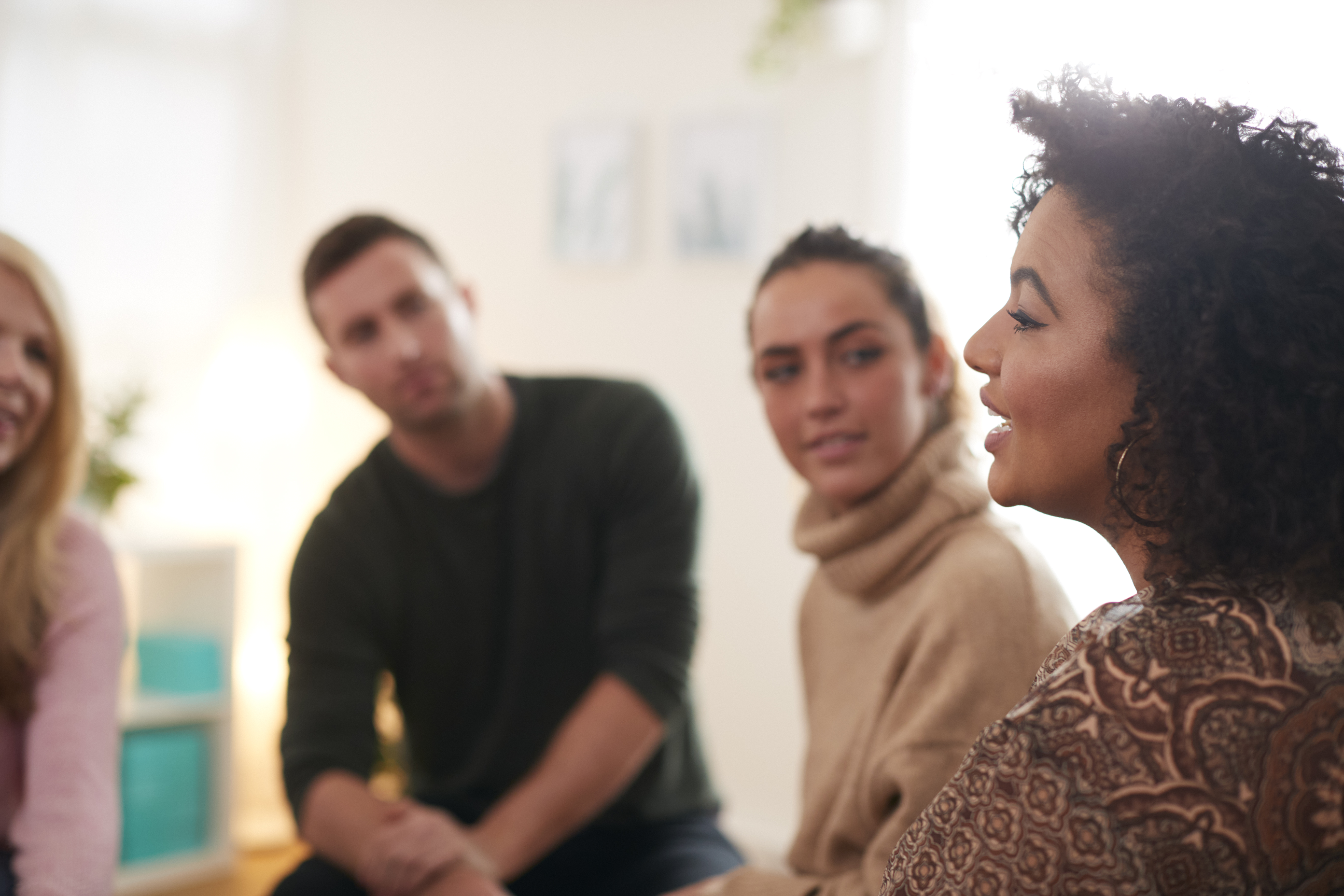 Team meeting with woman speaking in foreground